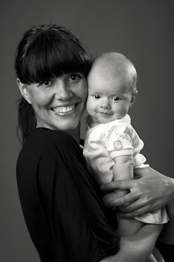 Porträtt av nybliven mamma med spädbarn i fotostudio