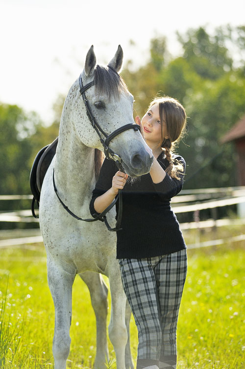 En vit häst blir en bra reflexskärm för porträtt utomhus i solljus