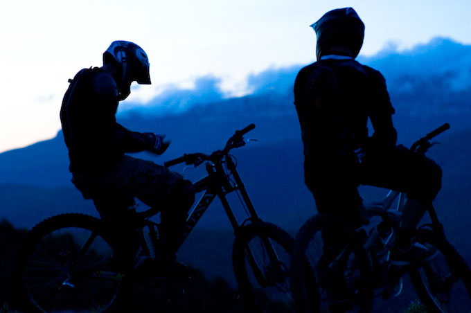 Silhuett av tv&aring; mountainbike-cyklister mot berg &amp; himmel. Foto: Stefan Tell