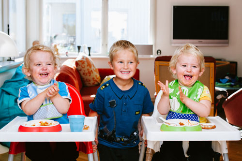 tre-glada-barn-tvillingar-fotograferade-i-hemmastudio